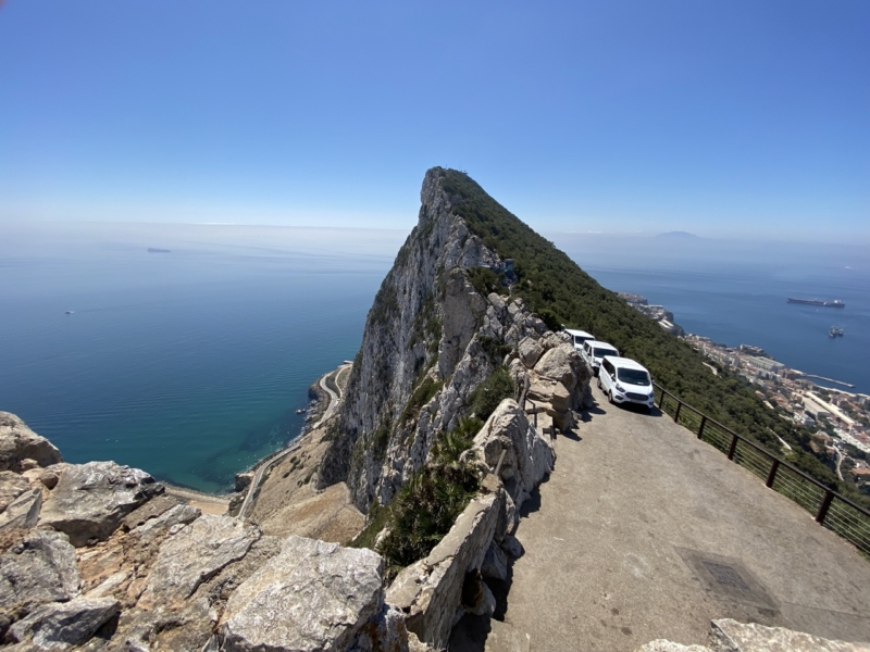 Čo vidieť na Gibraltáre - Gibraltárska skala a vpredu miestne autá, ktoré vyvezú turistov na vrchol