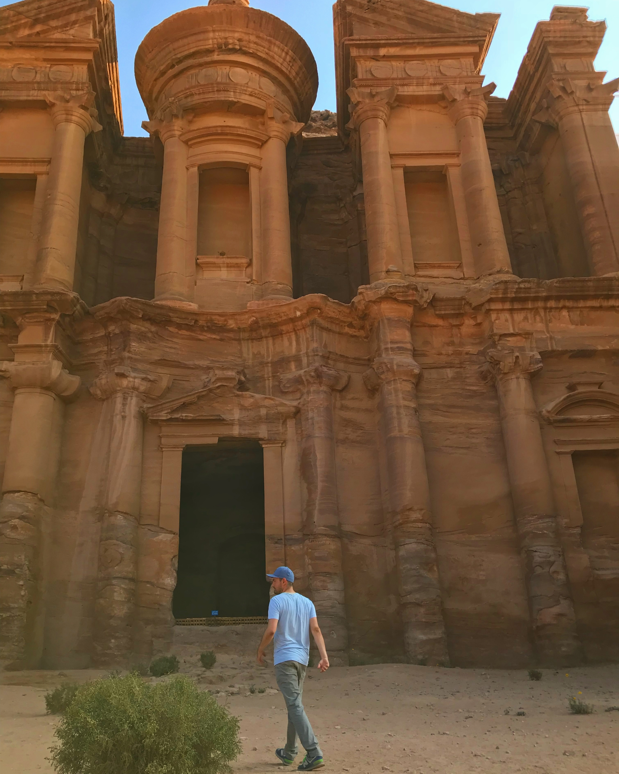 Itinerár na 8 dní po Jordánsku - Človek kráčajúci pred hrobkou vytesanou do skaly v skalnom meste Petra